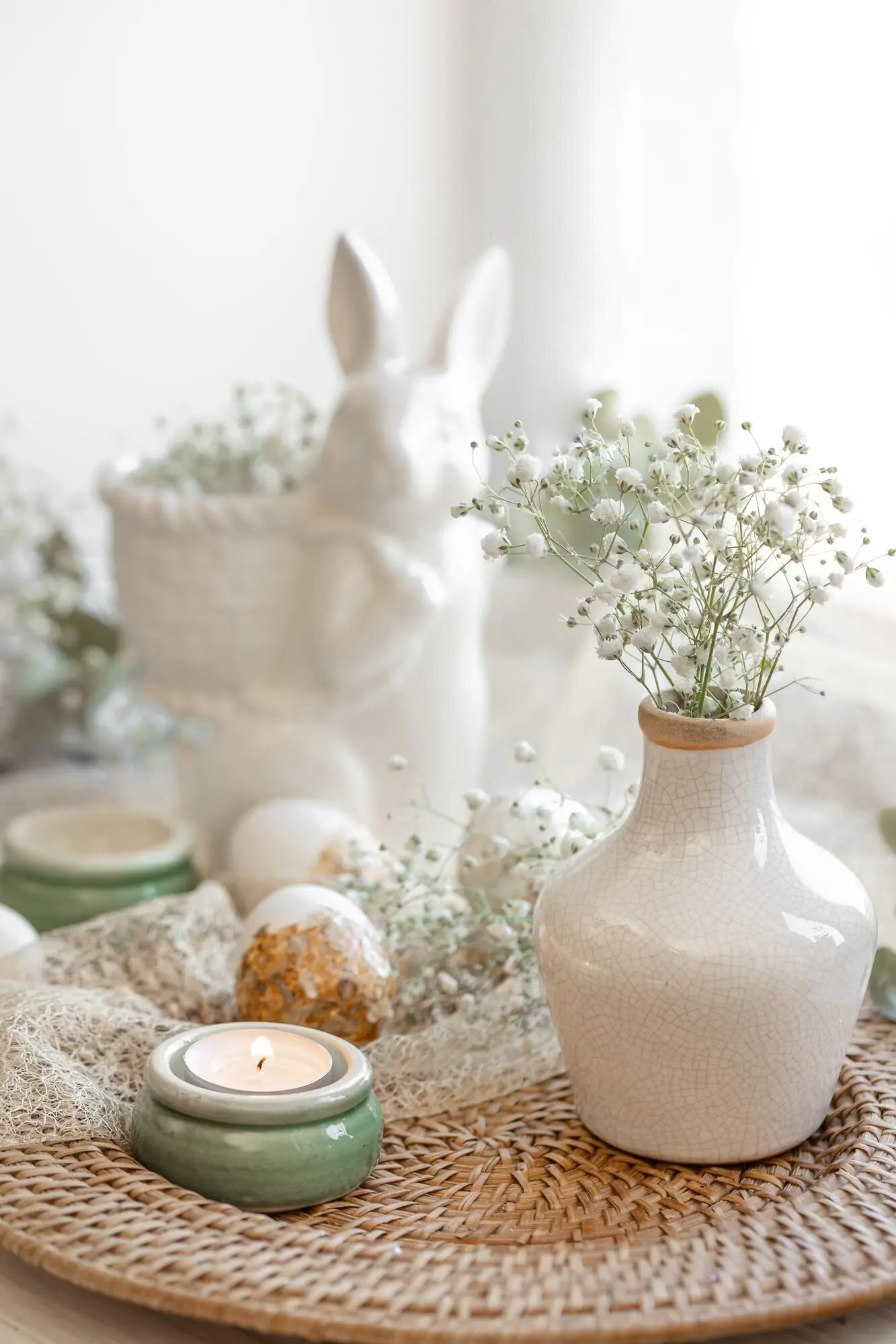 Österliche Komposition mit einem Keramikhasen und Schleierkrautblüten